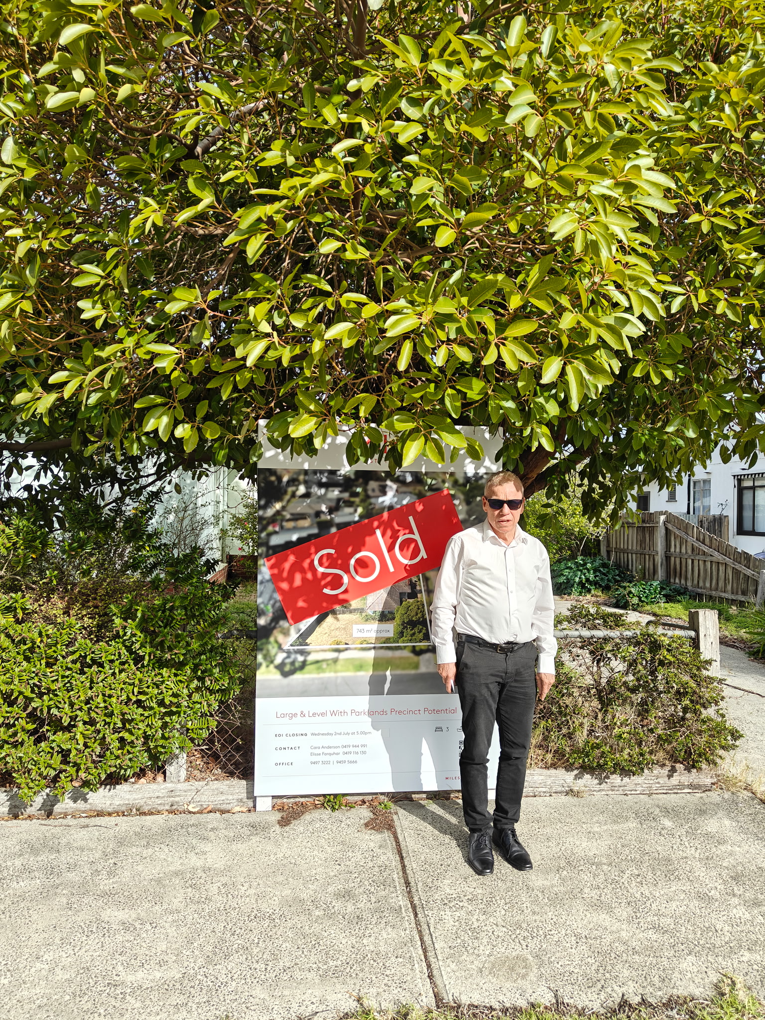 Mark Thompson of MPS Advocates standing beside a sold property board in Melbourne