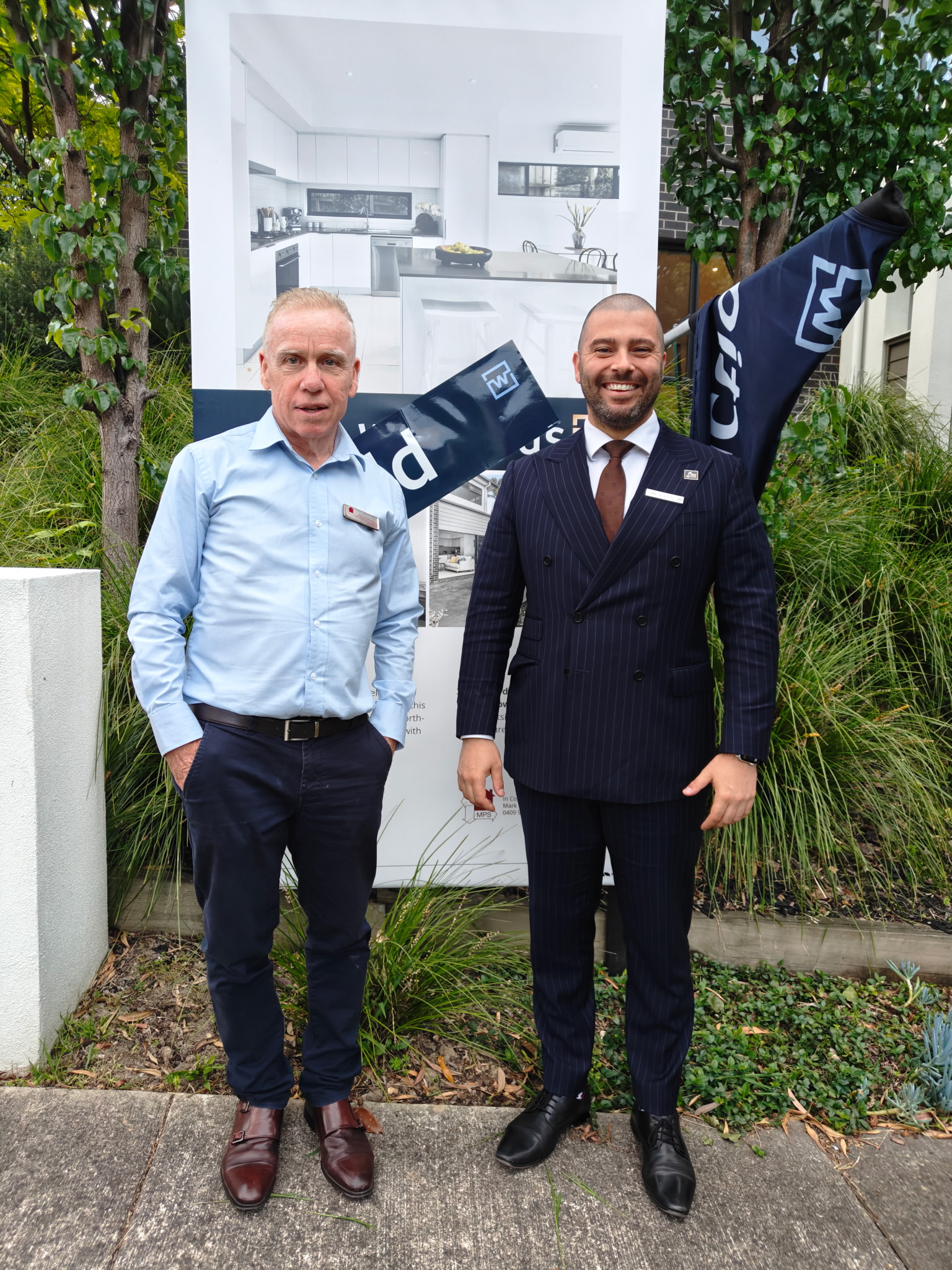Mark Thompson of MPS Advocates with a Melbourne real estate professional beside a sold property board