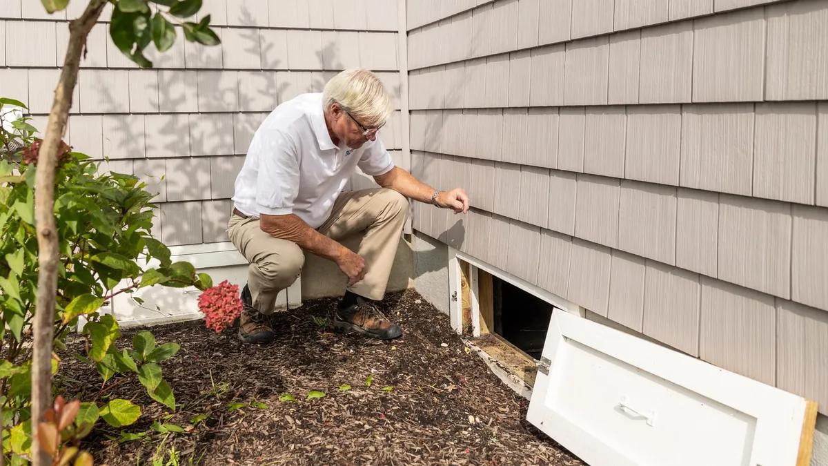 Home inspector examining a property's underfloor crawl space
